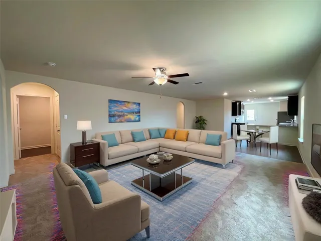 a living room with furniture and a view of kitchen