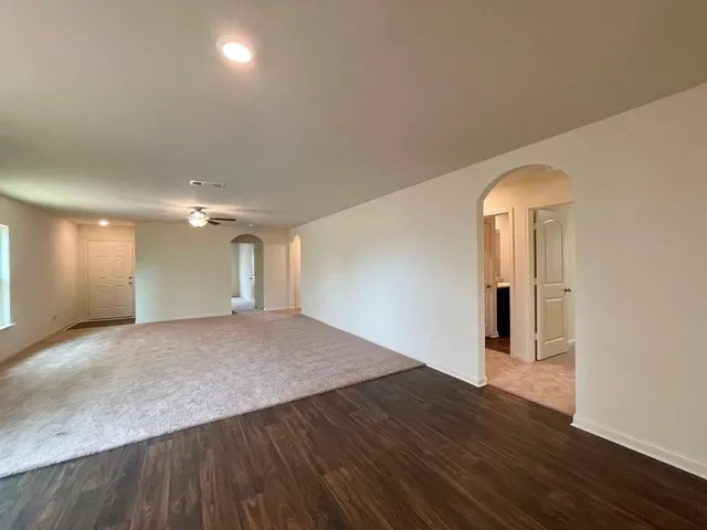 an empty room with wooden floor and window