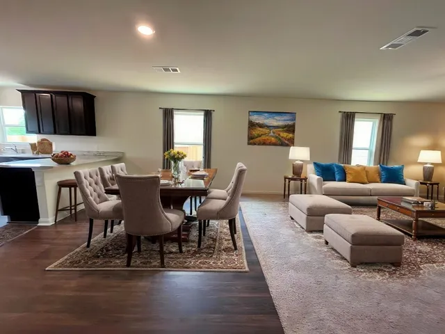 a living room with furniture a flat screen tv and a window