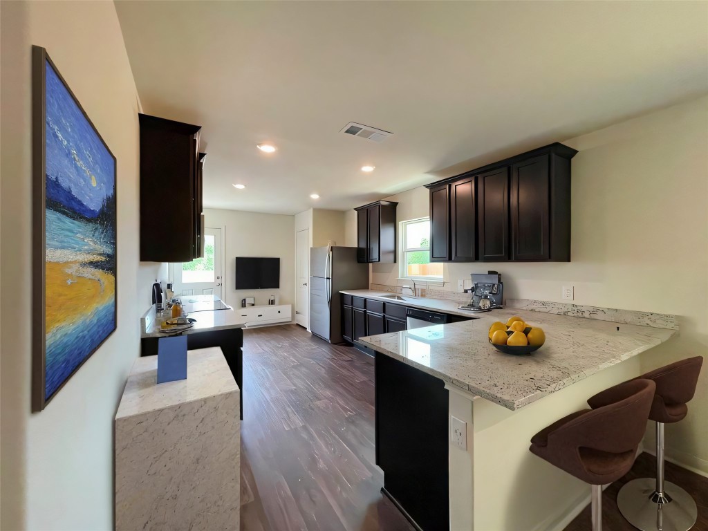 168 Allington Circle Jarrell, TX 76537 - Photo 10 of 40 a kitchen with a stove a sink and a refrigerator