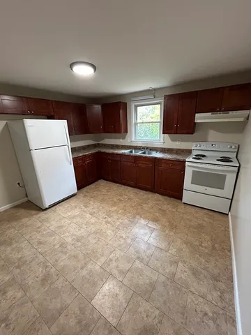a kitchen with granite countertop a refrigerator and a stove