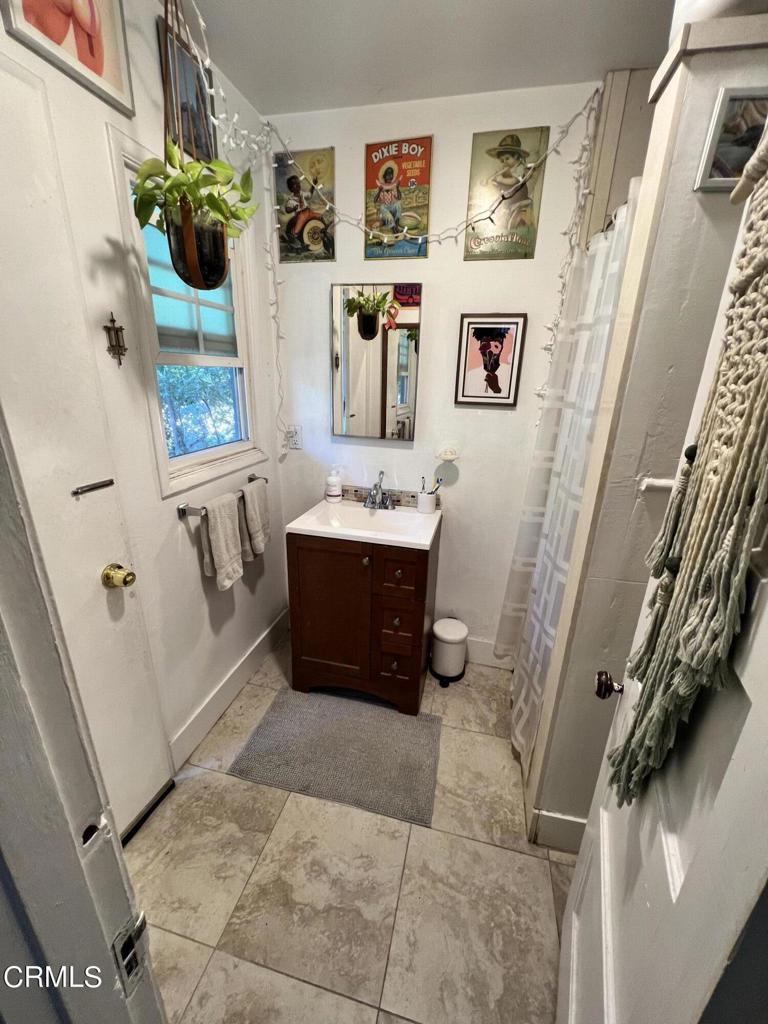 1445 East Woodbury Road, Unit REAR Pasadena, CA 91104 - Photo 12 of 17 a bathroom with a tub sink and mirror