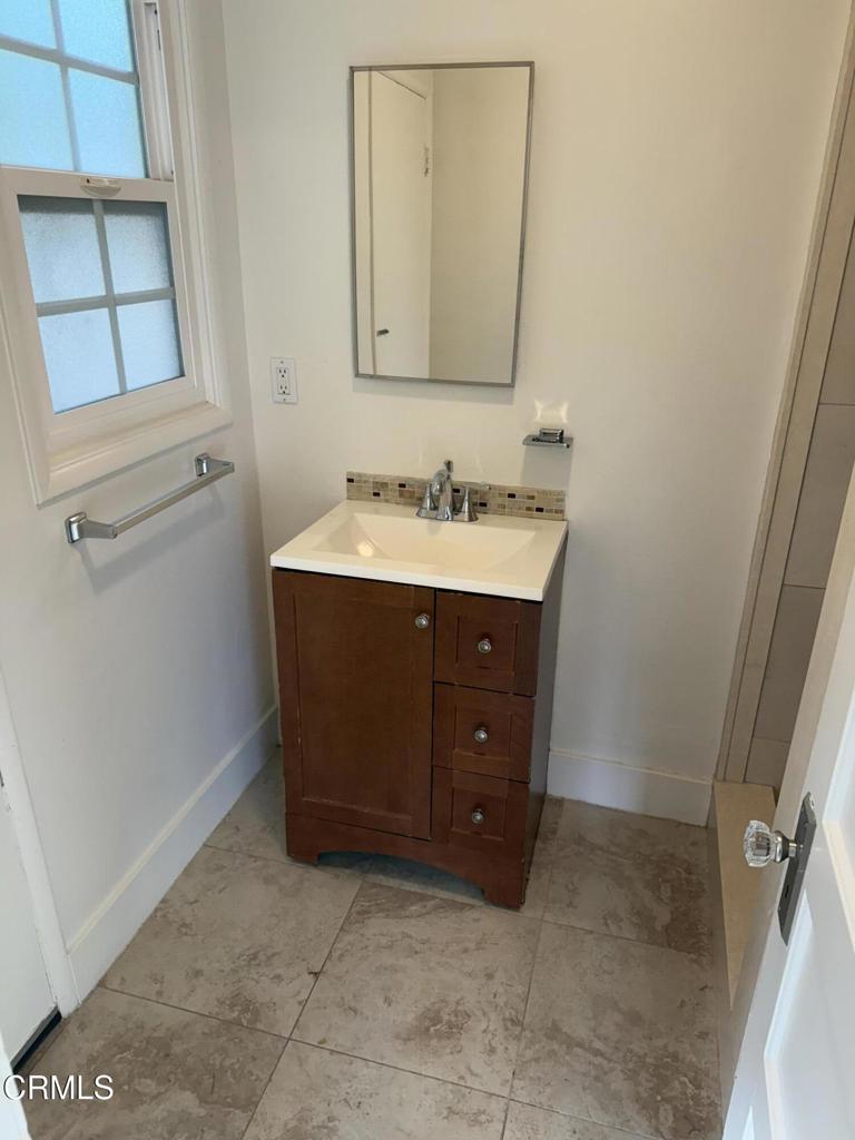 1445 East Woodbury Road, Unit REAR Pasadena, CA 91104 - Photo 15 of 17 a bathroom with a sink vanity and mirror