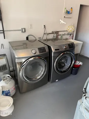 a utility room with sink dryer and washer