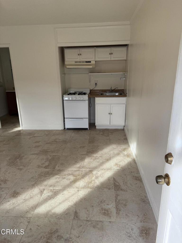 1445 East Woodbury Road, Unit REAR Pasadena, CA 91104 - Photo 17 of 17 a view of a kitchen with white cabinets and white appliances