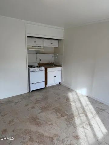 a kitchen with stainless steel appliances a stove and white cabinets