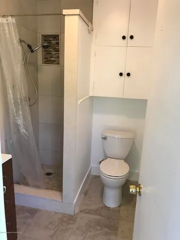 a bathroom with a toilet and a shower