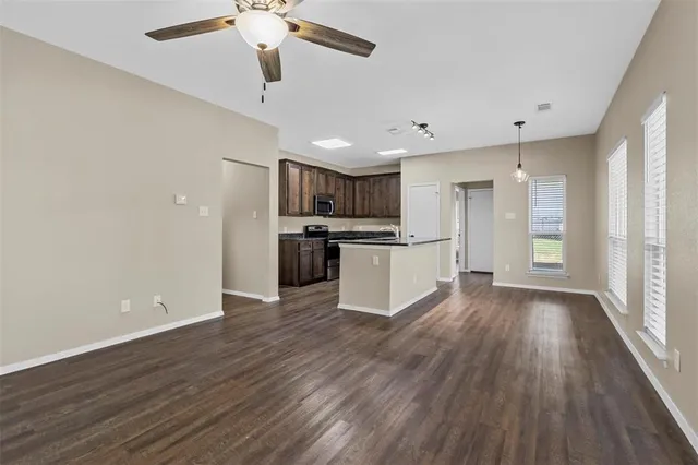 a view of kitchen with refrigerator microwave and stove top oven