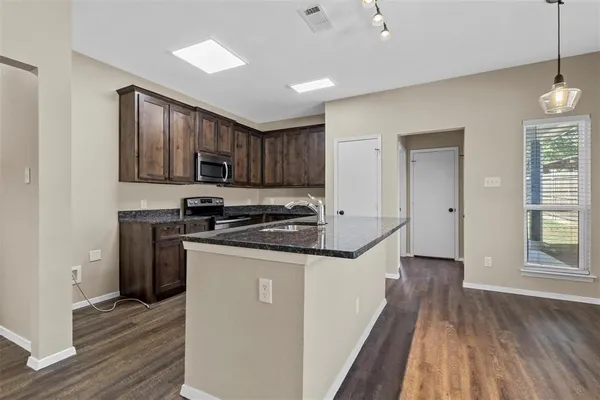 a kitchen with stainless steel appliances granite countertop a stove a sink and a refrigerator