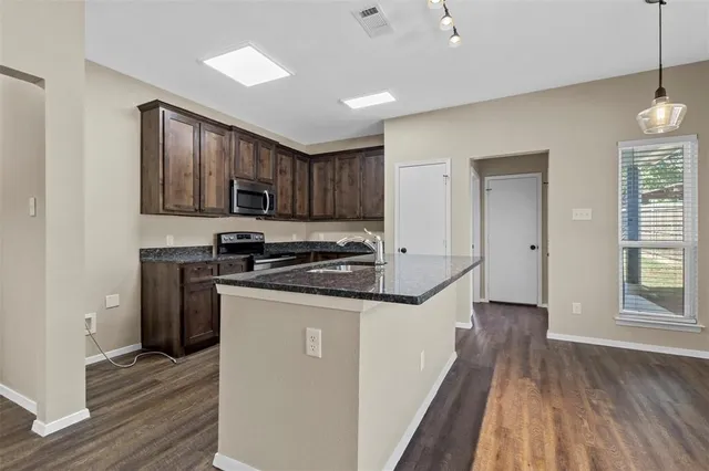 a kitchen with stainless steel appliances granite countertop a stove a sink and a refrigerator