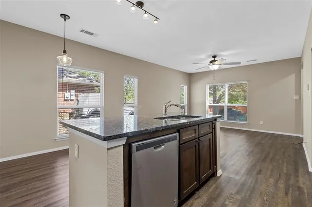 a kitchen with kitchen island a sink appliances and wooden floor
