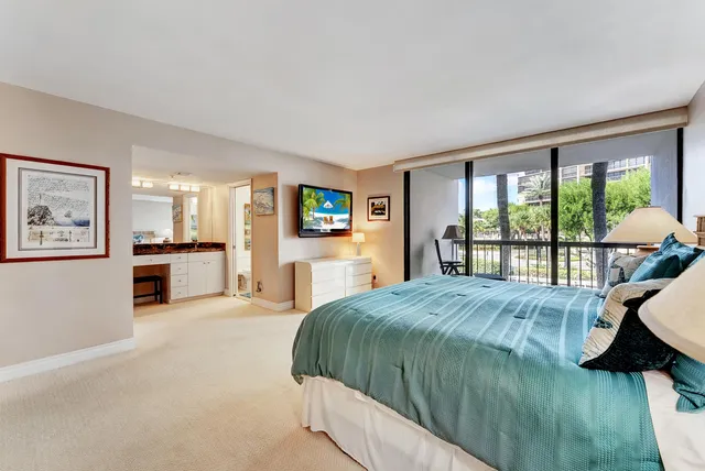 a large spacious bathroom with a granite countertop toilet a sink and a large mirror