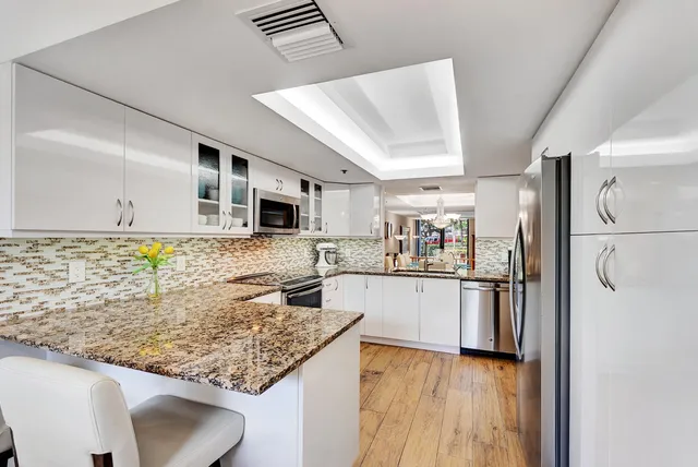 a kitchen with stainless steel appliances granite countertop a refrigerator and a stove