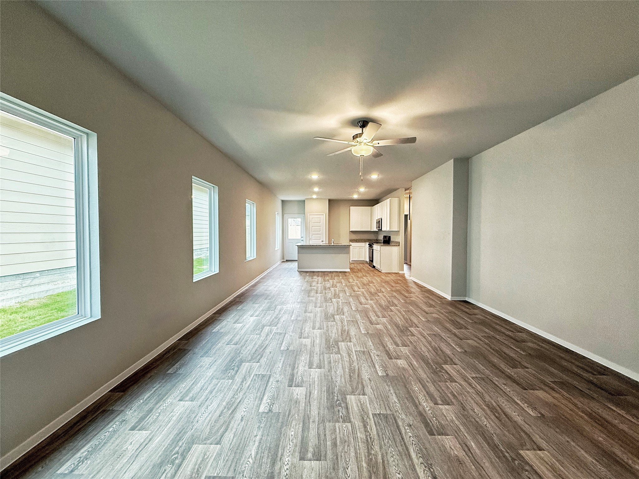 2714 Towy Road Manor, TX 78653 - Photo 20 of 22 An open floor plan with rich wood-look flooring extends towards the modern kitchen.