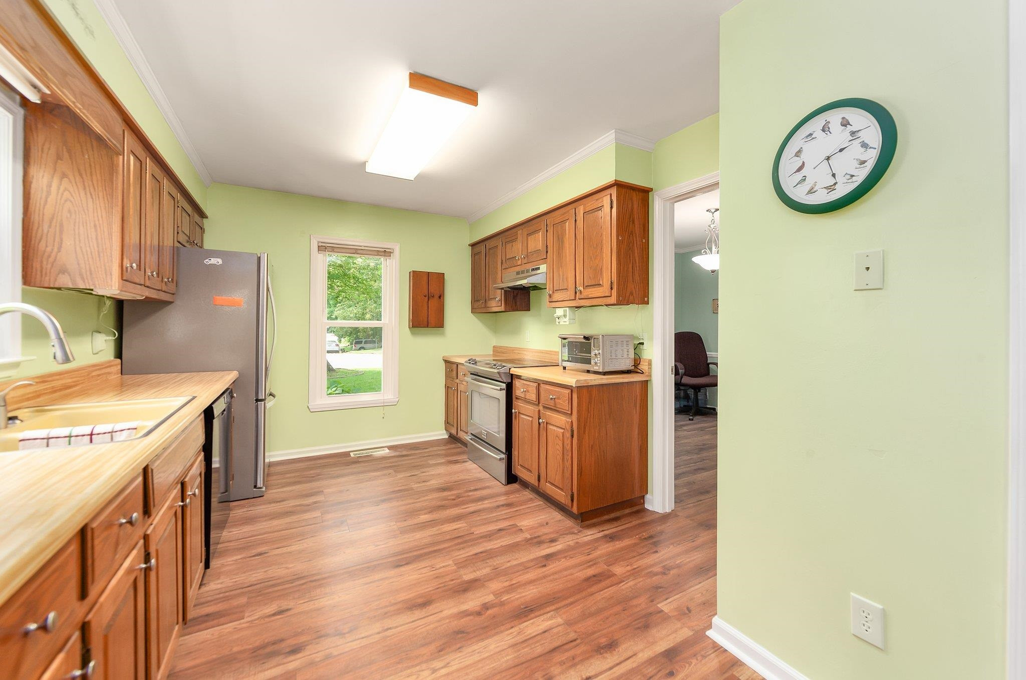 56 Ridgeoak Place Jackson, TN 38305 - Photo 4 of 34 a kitchen with a refrigerator a stove top oven with wooden floor