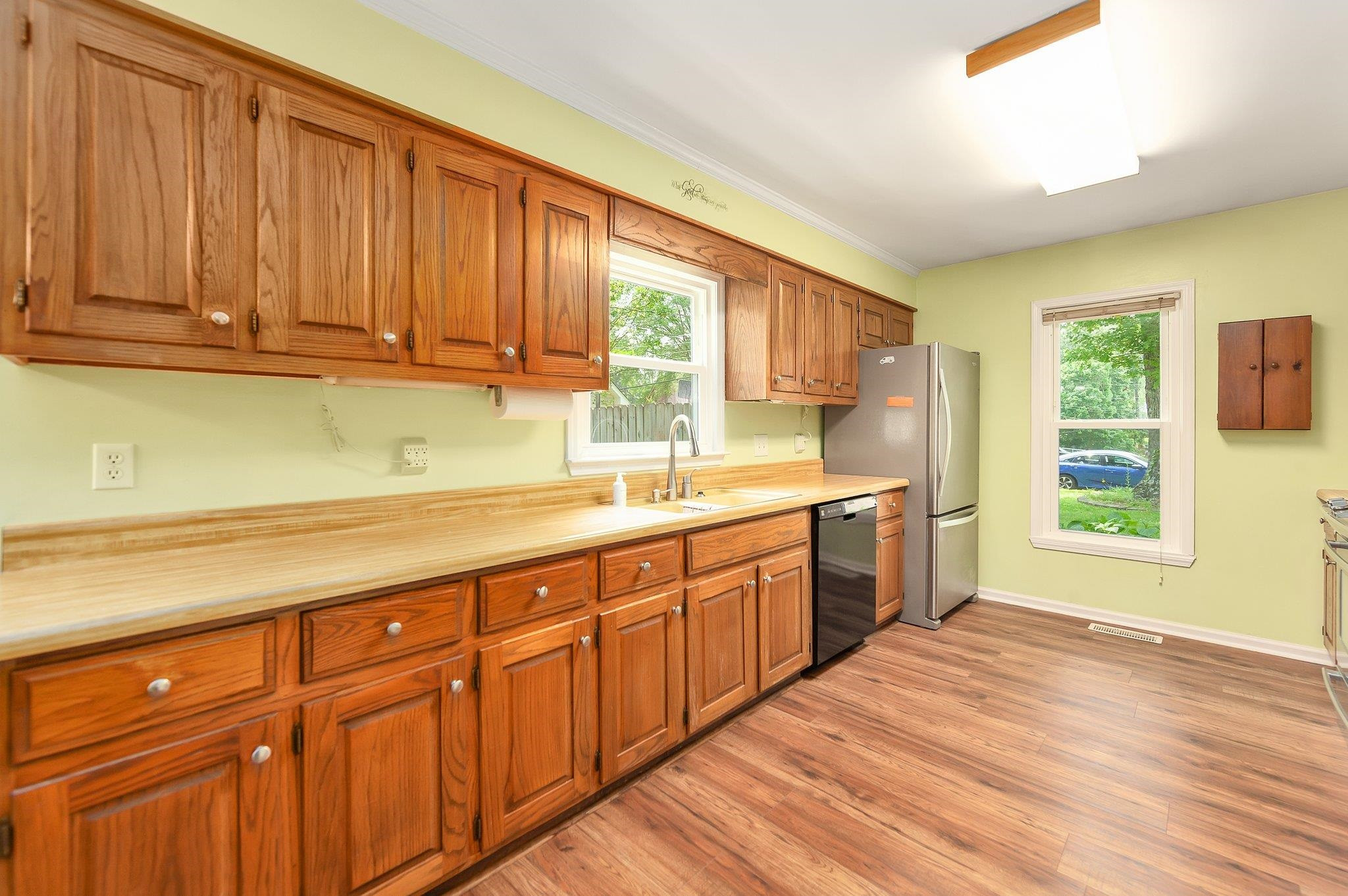 56 Ridgeoak Place Jackson, TN 38305 - Photo 6 of 34 a kitchen with stainless steel appliances granite countertop a sink dishwasher cabinets with a flat screen tv and wooden floor