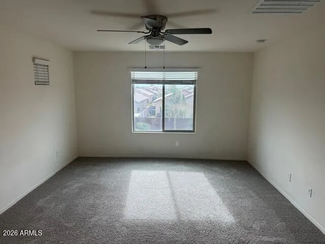 an empty room with a window and a ceiling fan