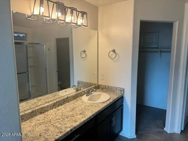 a bathroom with a granite countertop sink and a mirror