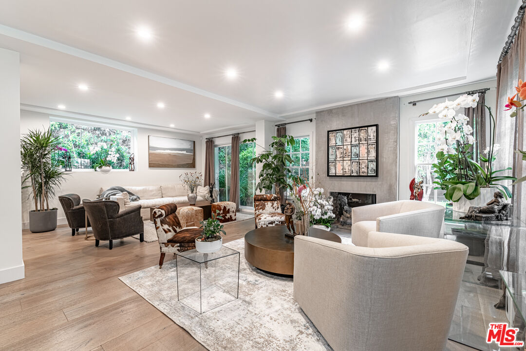 1438 San Ysidro Drive Beverly Hills, CA 90210 - Photo 1 of 40 a living room with furniture potted plant floor to ceiling windows and a fireplace