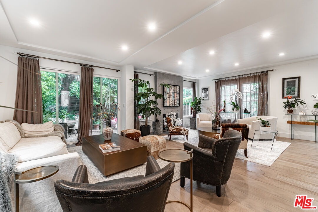 1438 San Ysidro Drive Beverly Hills, CA 90210 - Photo 2 of 40 a living room with fireplace furniture and floor to ceiling windows