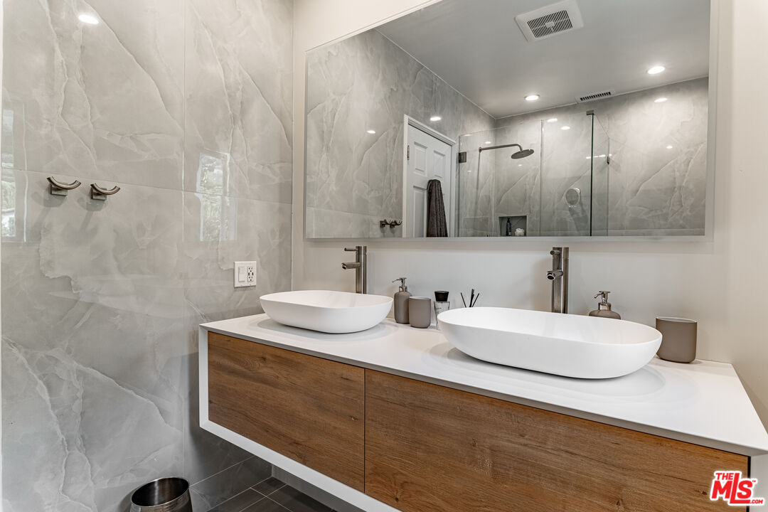 1438 San Ysidro Drive Beverly Hills, CA 90210 - Photo 30 of 40 a bathroom with double vanity sinks and a mirror