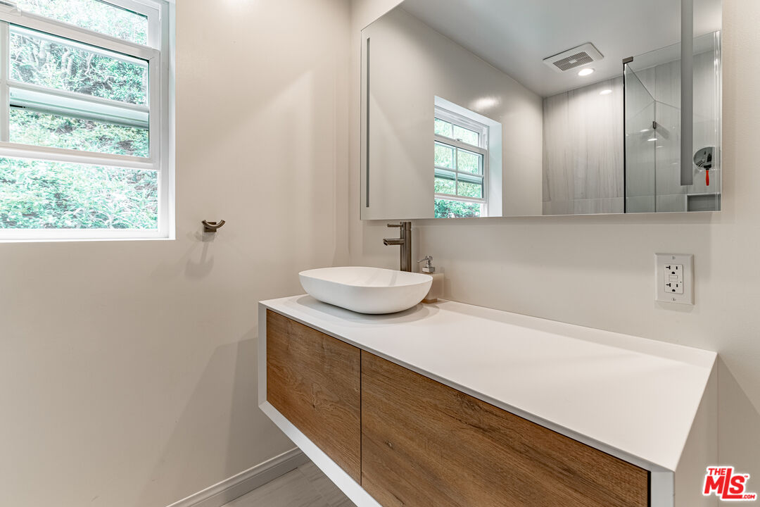 1438 San Ysidro Drive Beverly Hills, CA 90210 - Photo 37 of 40 a bathroom with a sink and a mirror