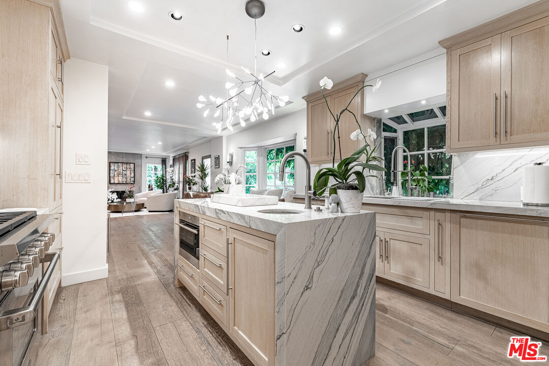 1438 San Ysidro Drive Beverly Hills, CA 90210 - Photo 4 of 40 a large white kitchen with a large window a sink and stainless steel appliances