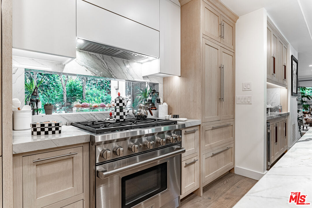 1438 San Ysidro Drive Beverly Hills, CA 90210 - Photo 5 of 40 a kitchen with stainless steel appliances a stove and a refrigerator