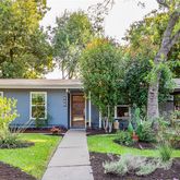 a front view of a house with a yard and potted plants