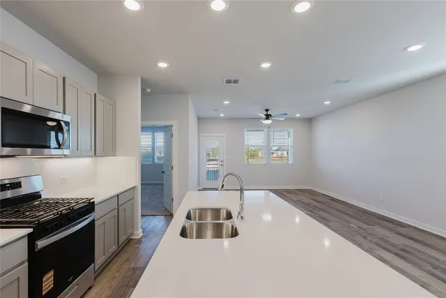 a kitchen with a sink a stove and cabinets
