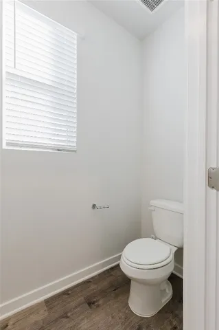 a white toilet sitting next to a window