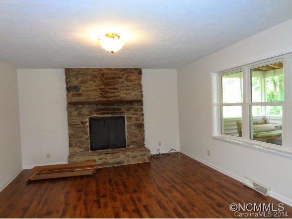 80 Merida Gap Road Canton, NC 28716 - Photo 8 of 18 an empty room with wooden floor fireplace and windows