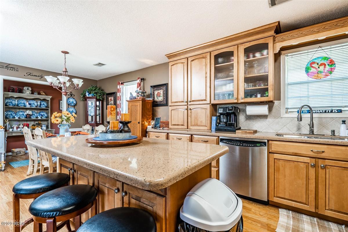 6180 Skipperton Road Macon, GA 31216 - Photo 12 of 37 a kitchen with a table chairs stove and cabinets