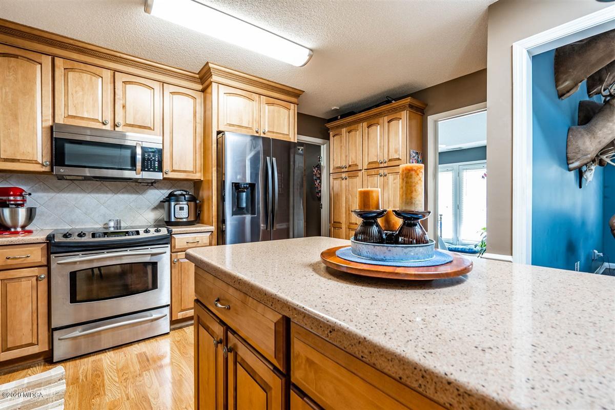 6180 Skipperton Road Macon, GA 31216 - Photo 9 of 37 a kitchen with stainless steel appliances granite countertop a stove a sink dishwasher a refrigerator and a dining table with wooden floor