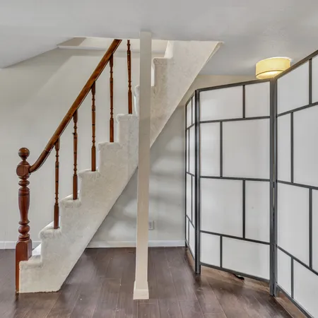 a spacious bedroom with a bed and wooden floor