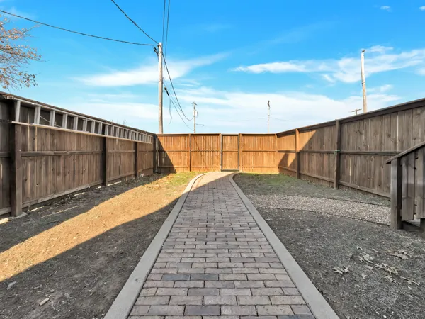 a living room with furniture a floor to ceiling window and kitchen view