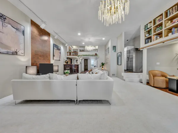 a living room with furniture and a chandelier
