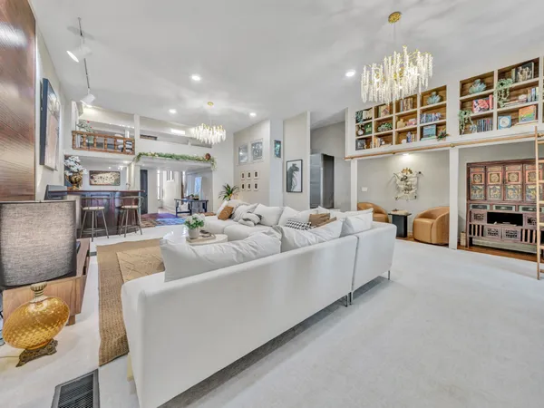 a living room with furniture and a chandelier