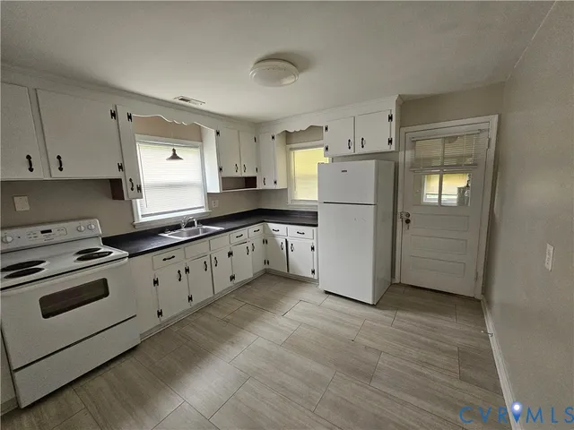 a kitchen with granite countertop white cabinets and white appliances