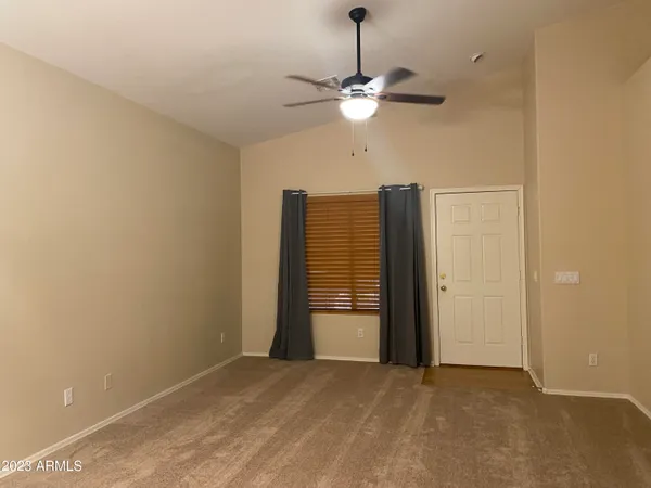 an empty room with a chandelier fan and closet