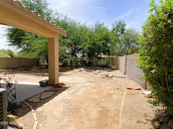 a view of a yard with plants and a table and chairs