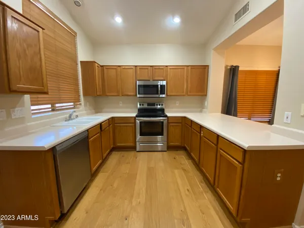 a kitchen with kitchen island granite countertop a sink a counter top space stainless steel appliances and cabinets