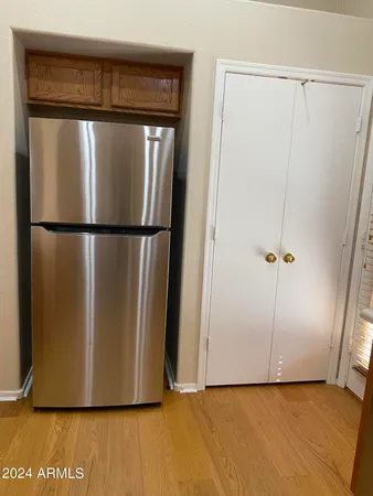 a view of a refrigerator in kitchen and an empty room
