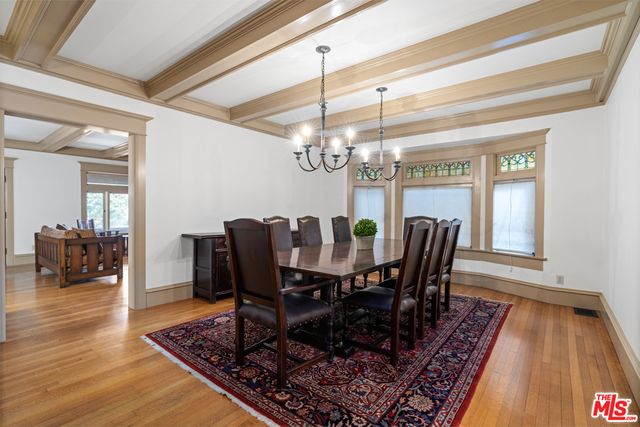a view of a dining room with furniture a rug and wooden floor