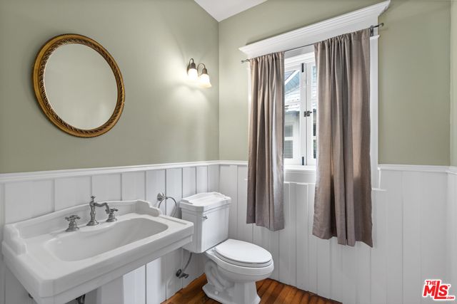 a bathroom with a toilet a sink and a mirror