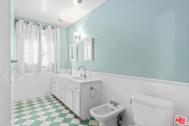 a bathroom with a sink a toilet and a mirror