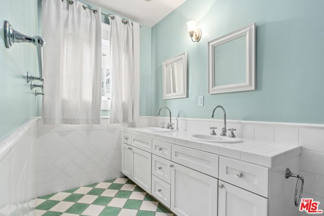 a bathroom with a double vanity sink mirror and