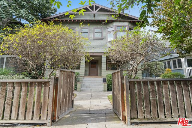 a view of house with wooden fence and trees