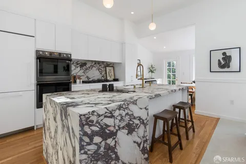 a kitchen with kitchen island a stove a table and chairs in it