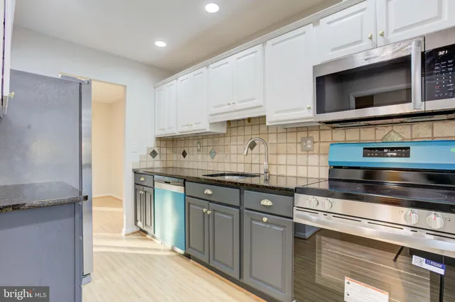 a kitchen with stainless steel appliances granite countertop a stove and a microwave